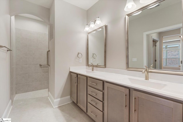 bathroom with tile flooring, double sink vanity, and an enclosed shower