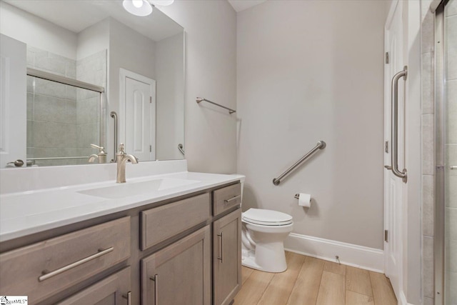 bathroom featuring wood-type flooring, vanity, and toilet