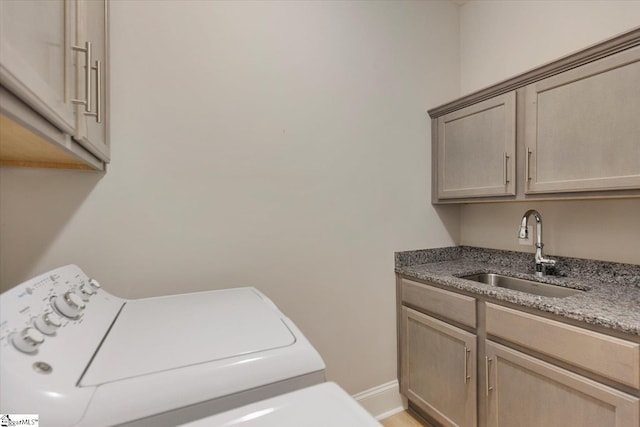 clothes washing area with sink, cabinets, and washer / clothes dryer