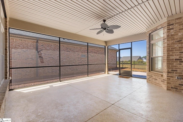 unfurnished sunroom featuring ceiling fan