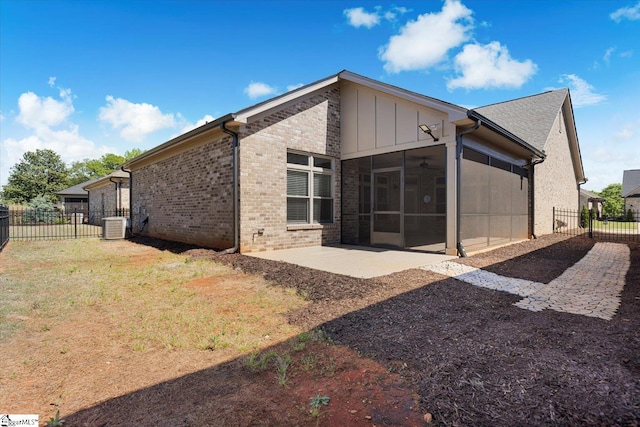 rear view of house with a patio, a sunroom, and central AC