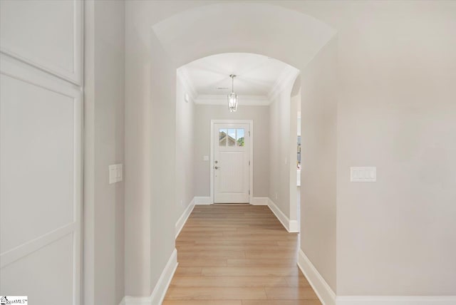 doorway to outside with ornamental molding and light hardwood / wood-style floors