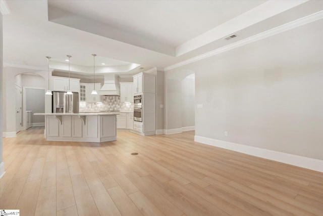 interior space featuring crown molding, light hardwood / wood-style floors, and a raised ceiling