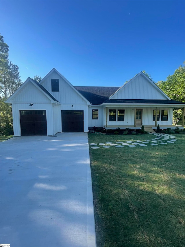 view of front of property with a garage, a porch, and a front yard