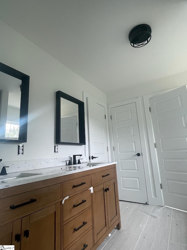 bathroom featuring tile flooring, large vanity, and double sink