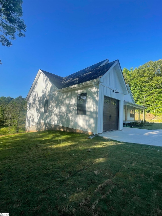 view of side of home with a garage and a lawn