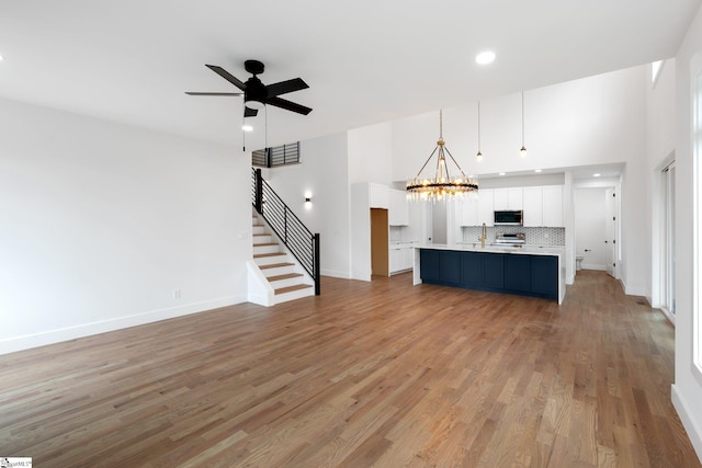 unfurnished living room with light hardwood / wood-style flooring and ceiling fan