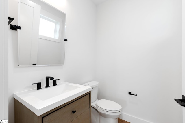 bathroom featuring vanity with extensive cabinet space and toilet