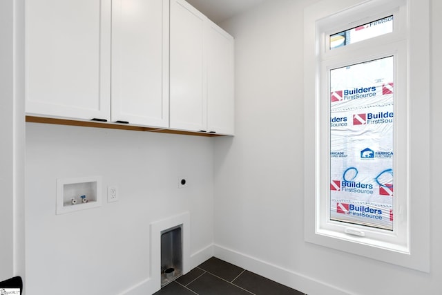 washroom featuring washer hookup, dark tile floors, electric dryer hookup, and cabinets