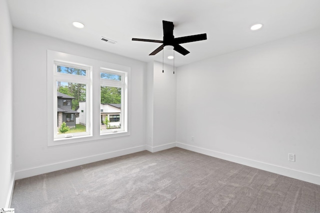 carpeted spare room with ceiling fan