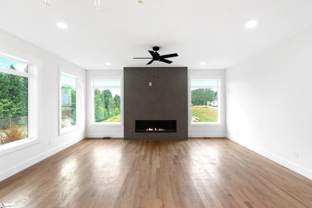 unfurnished living room with a healthy amount of sunlight and hardwood / wood-style flooring