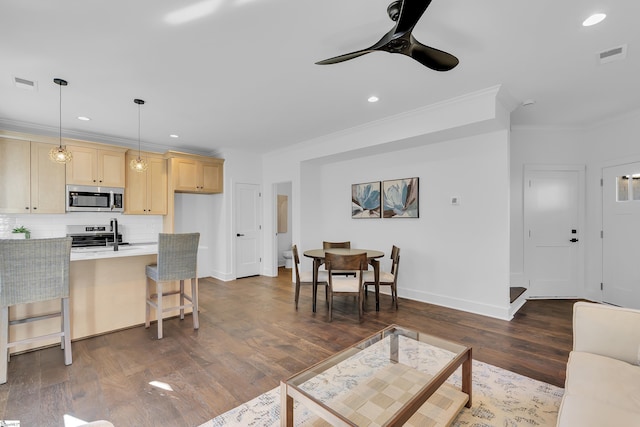 living area with visible vents, baseboards, ornamental molding, and dark wood-style flooring