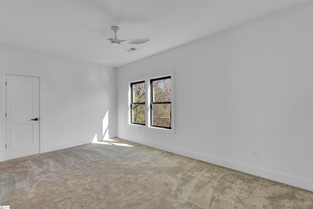 carpeted empty room featuring visible vents, baseboards, and ceiling fan