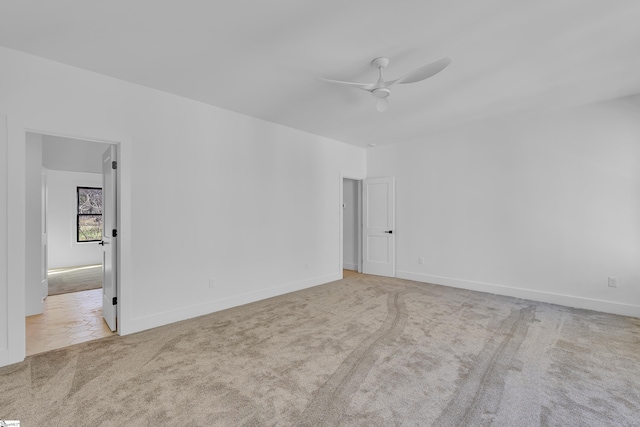 unfurnished room with baseboards, a ceiling fan, and carpet flooring