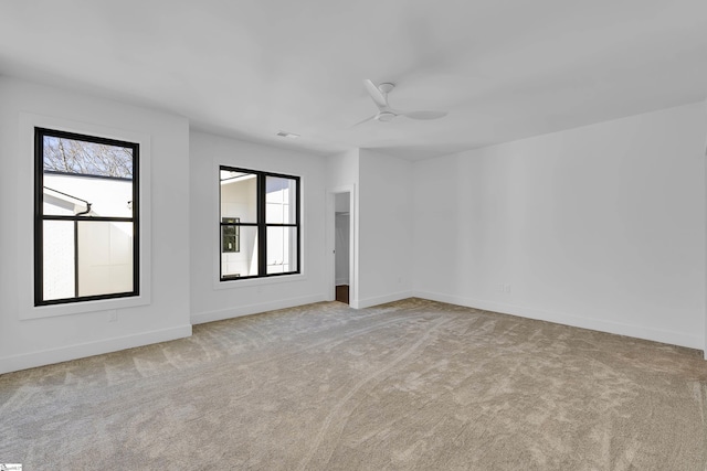 carpeted empty room with visible vents, baseboards, and ceiling fan