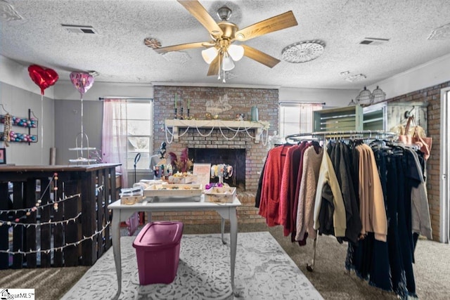 interior space with a fireplace, ceiling fan, carpet, and a textured ceiling