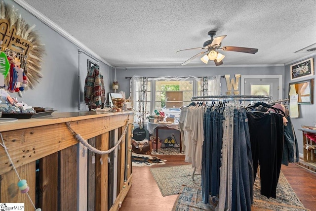 misc room with wood-type flooring, ceiling fan, and a textured ceiling