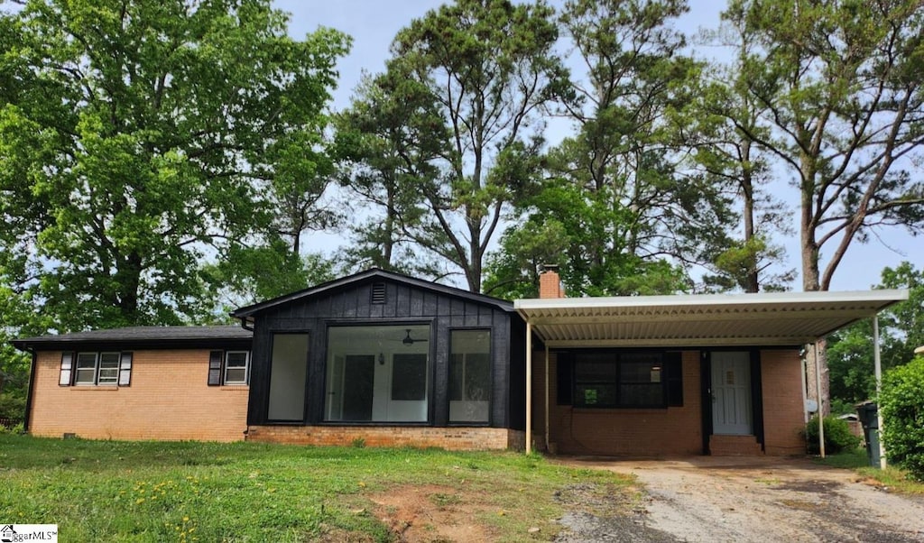 view of front of house with a front lawn and a carport