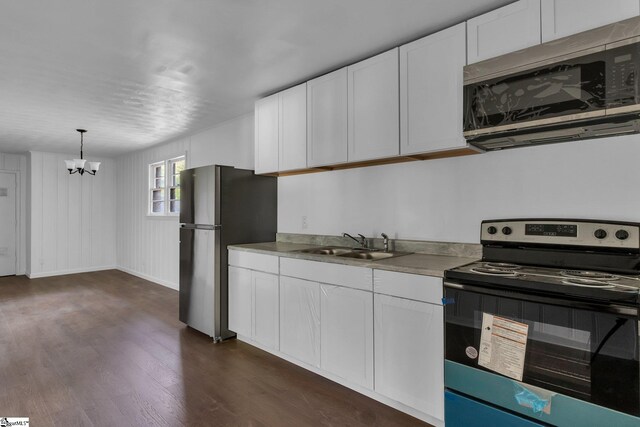 kitchen featuring stainless steel appliances, dark wood-type flooring, hanging light fixtures, sink, and white cabinets