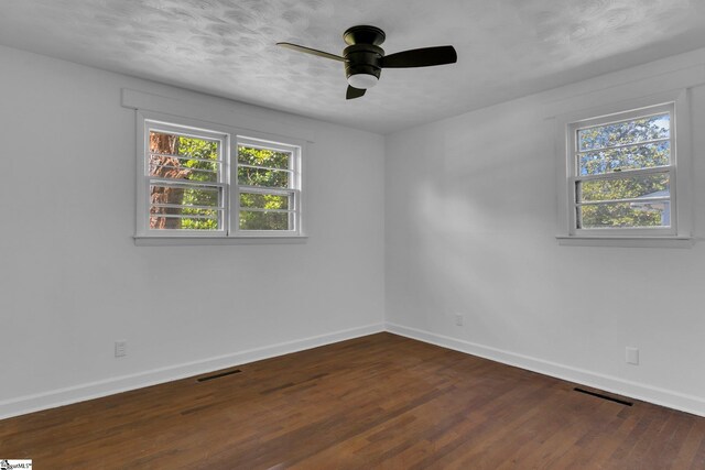 unfurnished room featuring dark wood-type flooring and ceiling fan