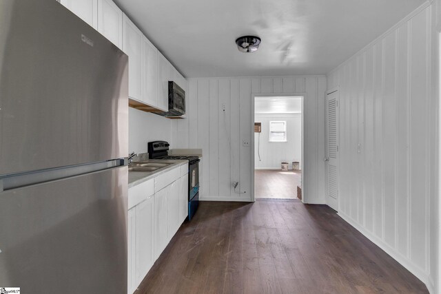 kitchen featuring dark hardwood / wood-style flooring, sink, white cabinetry, and stainless steel appliances