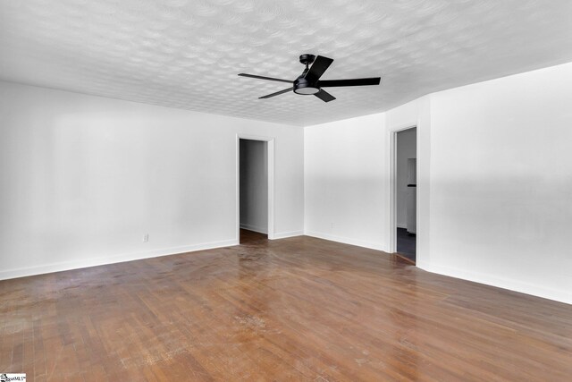 empty room with dark wood-type flooring and ceiling fan