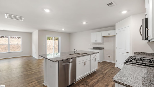 kitchen with appliances with stainless steel finishes, dark hardwood / wood-style flooring, sink, white cabinetry, and an island with sink