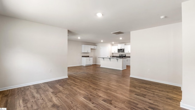 unfurnished living room featuring dark hardwood / wood-style flooring