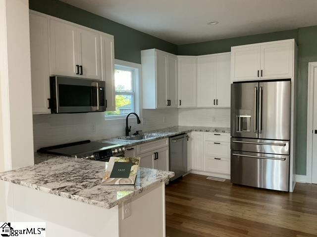 kitchen with white cabinets, dark hardwood / wood-style floors, sink, and stainless steel appliances