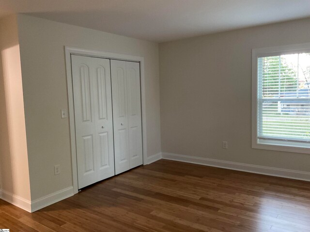 unfurnished bedroom featuring a closet and hardwood / wood-style floors