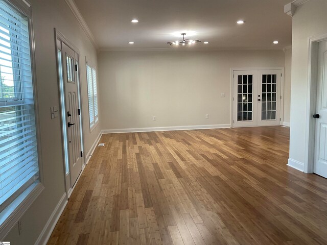 spare room featuring hardwood / wood-style floors, crown molding, and french doors