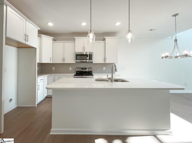 kitchen with sink, dark hardwood / wood-style flooring, hanging light fixtures, and white cabinetry