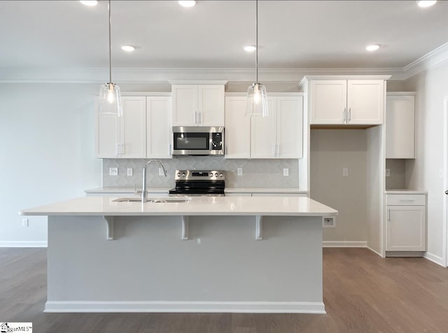 kitchen with a sink, light countertops, a center island with sink, and stainless steel appliances