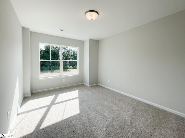 spare room with visible vents, baseboards, and carpet