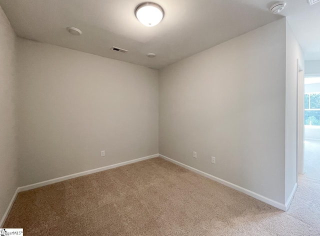 unfurnished room with visible vents, baseboards, and light carpet