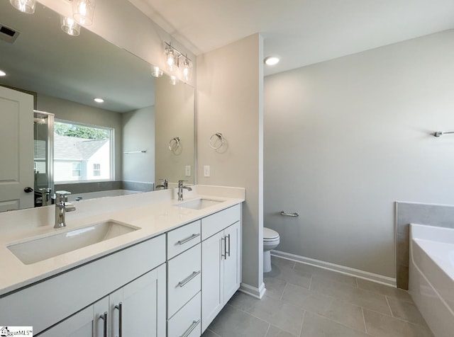 bathroom featuring double vanity, toilet, a bath, and a sink