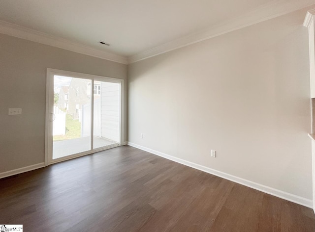 empty room featuring dark wood finished floors, visible vents, baseboards, and ornamental molding