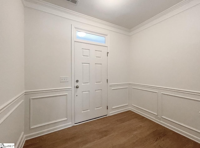 foyer entrance with ornamental molding and dark hardwood / wood-style floors