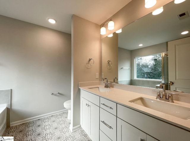 bathroom with vanity, a tub to relax in, tile patterned floors, and toilet