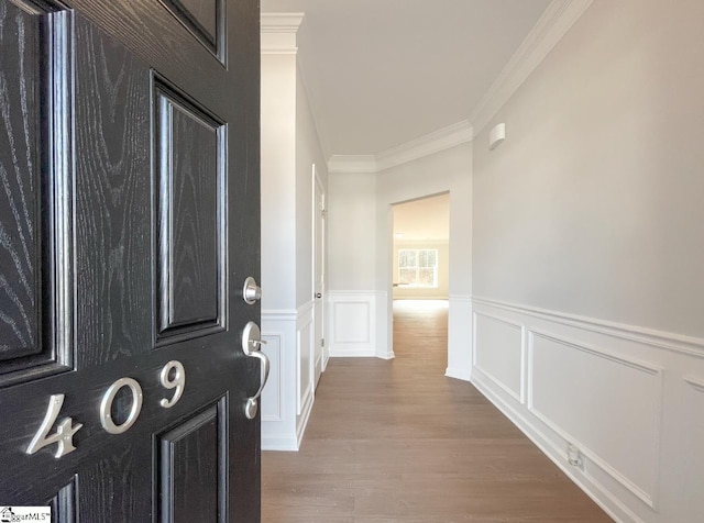 entryway featuring ornamental molding and wood-type flooring