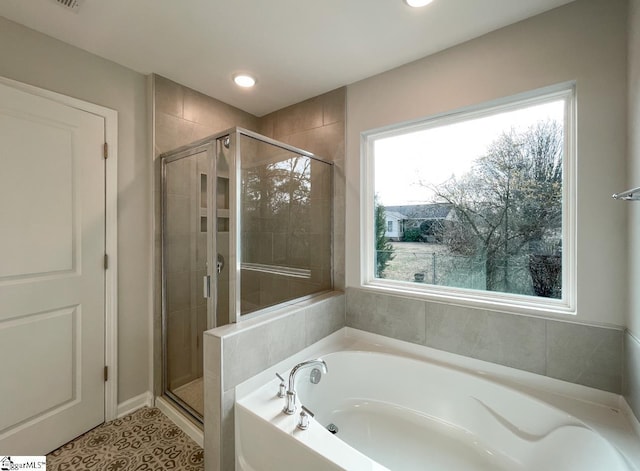 bathroom with tile patterned floors, independent shower and bath, and a healthy amount of sunlight