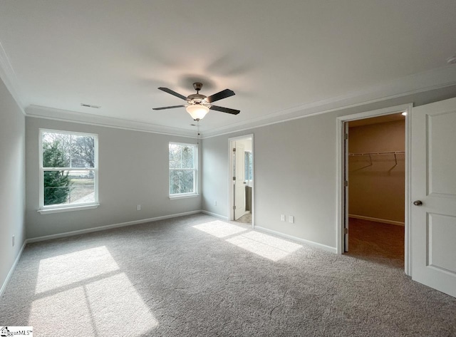 unfurnished bedroom with light carpet, crown molding, a walk in closet, and a closet