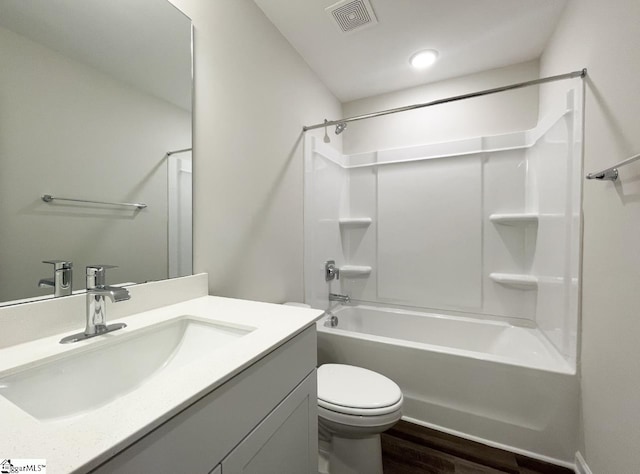 full bathroom featuring hardwood / wood-style floors, vanity, shower / washtub combination, and toilet