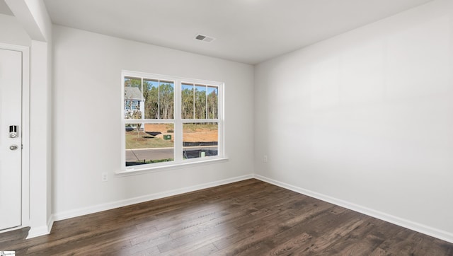 unfurnished room with dark wood-type flooring