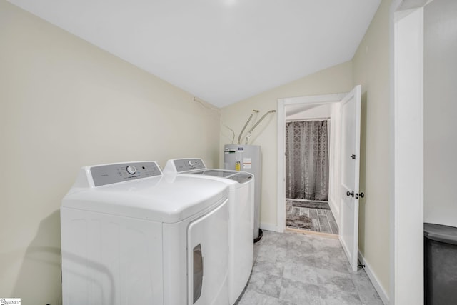 laundry area featuring water heater, washer and clothes dryer, and light tile floors