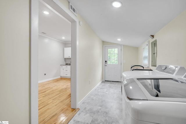 clothes washing area featuring washer and dryer, light hardwood / wood-style floors, and ornamental molding