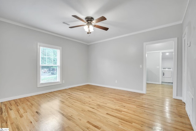 spare room featuring ceiling fan, light hardwood / wood-style floors, washer / dryer, and ornamental molding