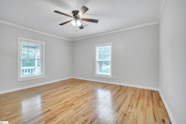 empty room featuring a wealth of natural light, ceiling fan, and light wood-type flooring