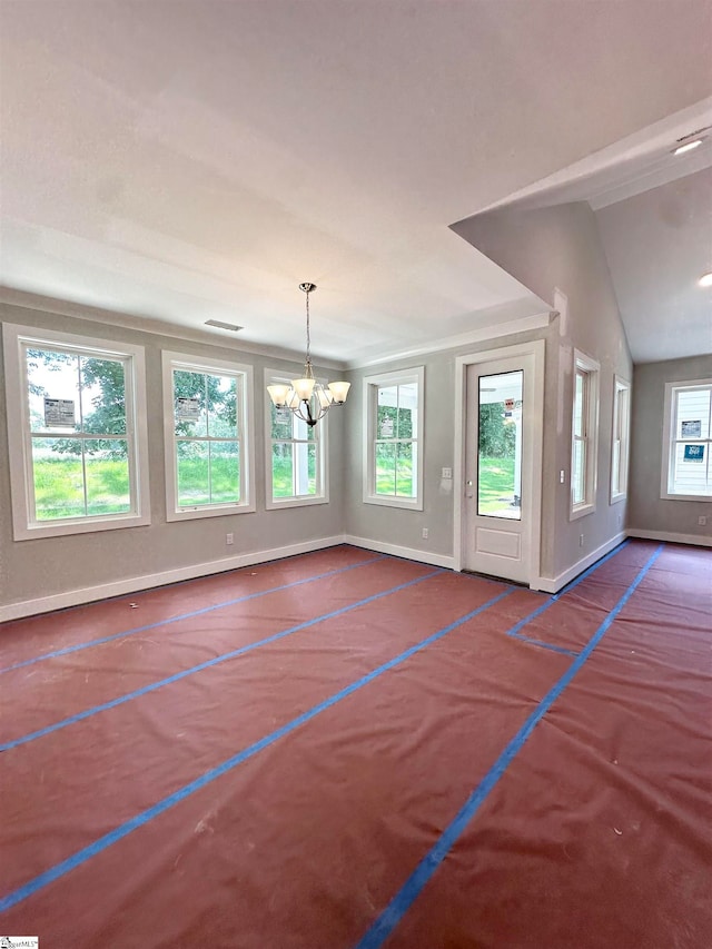 interior space featuring vaulted ceiling, a notable chandelier, and baseboards