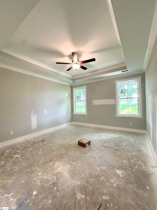 spare room featuring a raised ceiling, visible vents, baseboards, and ceiling fan